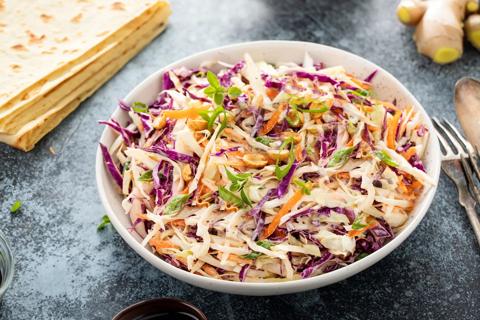 Bowl of Asian chicken slaw mixture with stacked tortillas, ginger and hoisin sauce