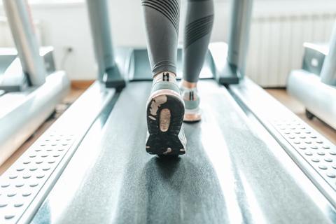 Legs and feet of person on a treadmill at the gym