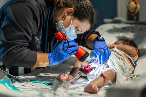 Nurse examines infant's central line