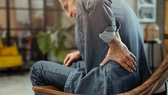 Man with hand on lower back indicating back pain