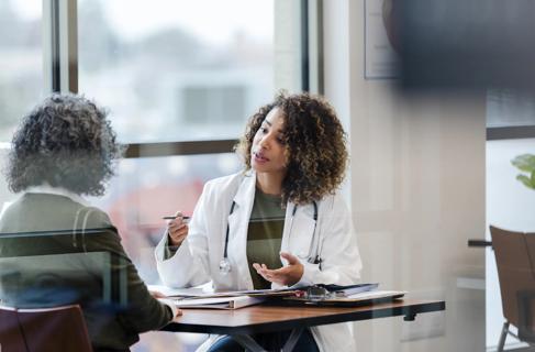 Healthcare provider speaking with patient across her desk