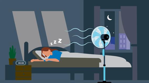 Woman sleeping in bed with fan blowing on her