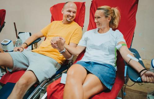 two people sitting and smiling outside