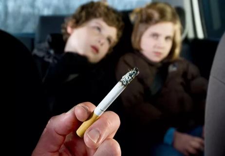 children in car suffering from secondhand smoke