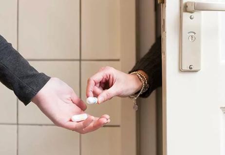 Woman getting handed a tampon.