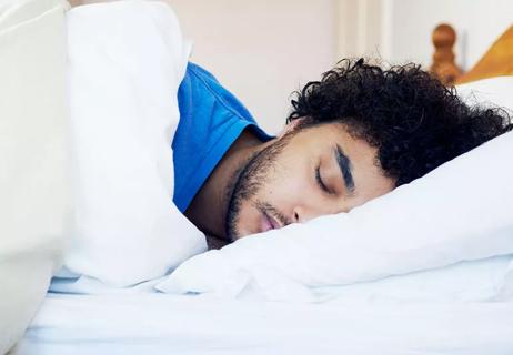 man sleeping in bed exhausted