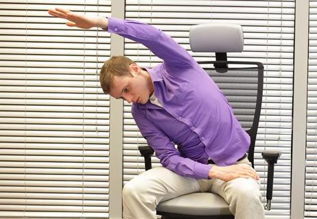 man performing yoga stretch at work