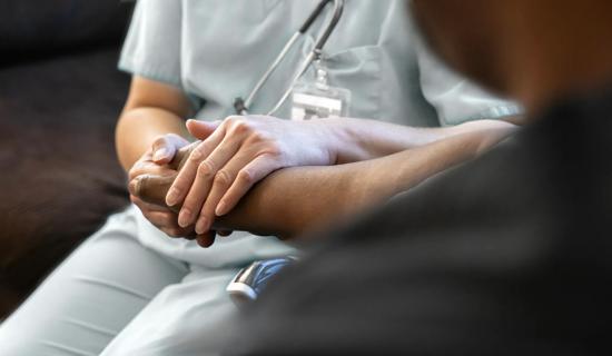 Nurse holding patient's hands