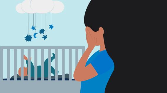 Mother with hands over her face, with newborn in their crib