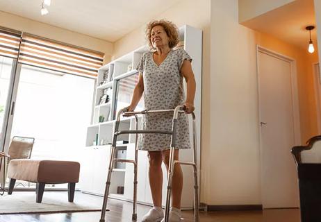 Elderly woman with a disability and a walker exercising