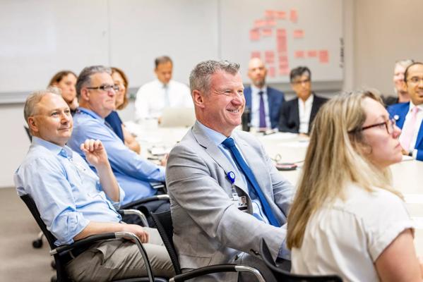 People gathered at a conference table for a meeting presentation.