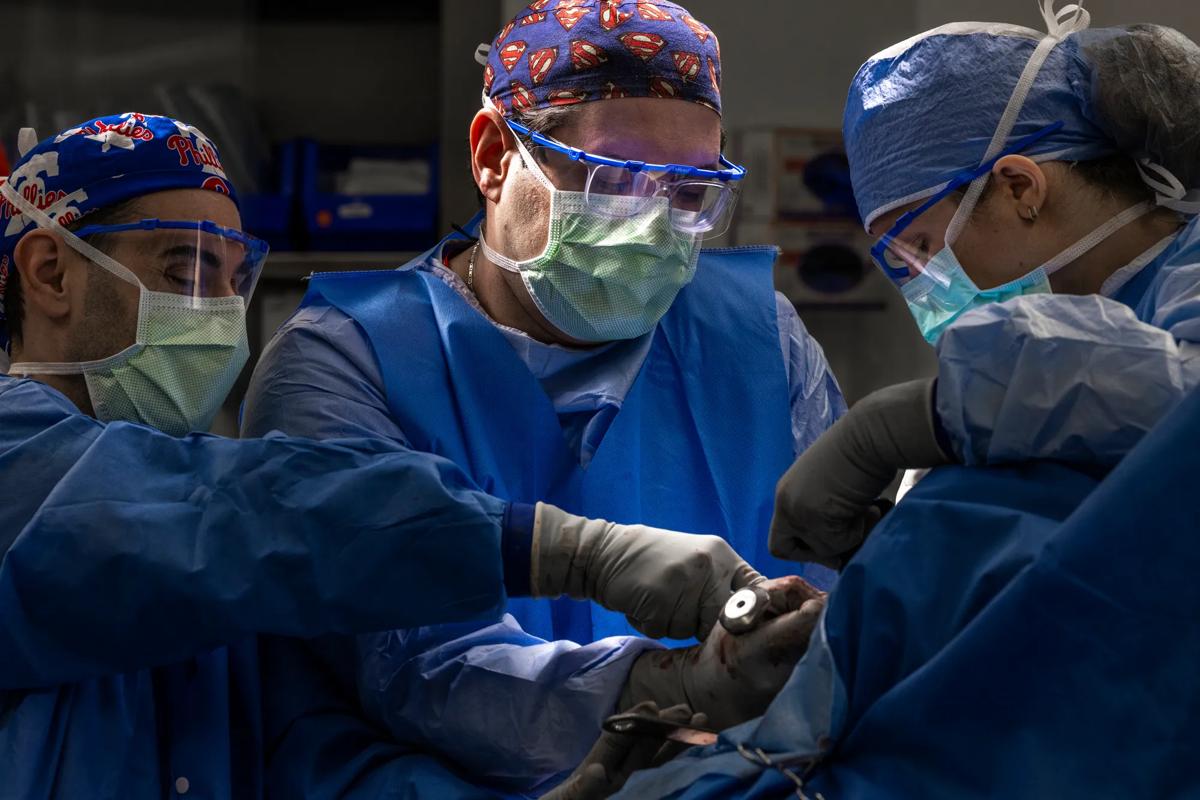 Three surgeons performing shoulder surgery in an operating room