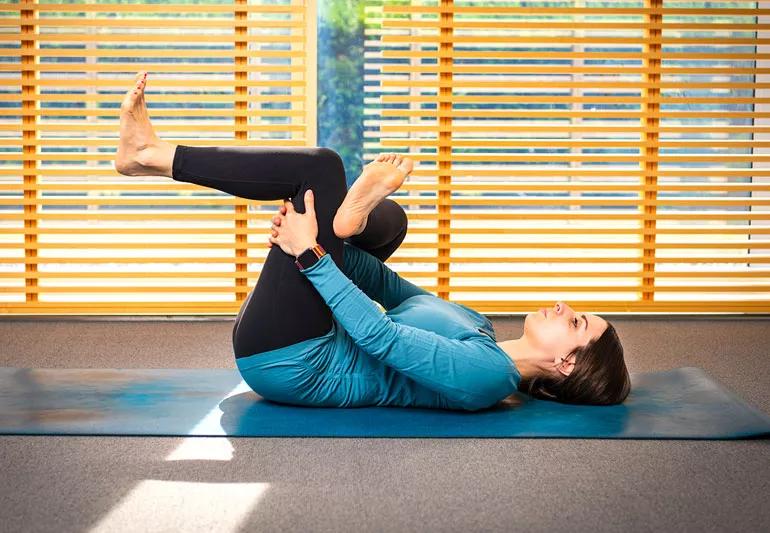 person on yoga mat in reclined half pigeon pose