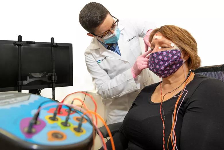 A doctor attaches sensors to a patient's face