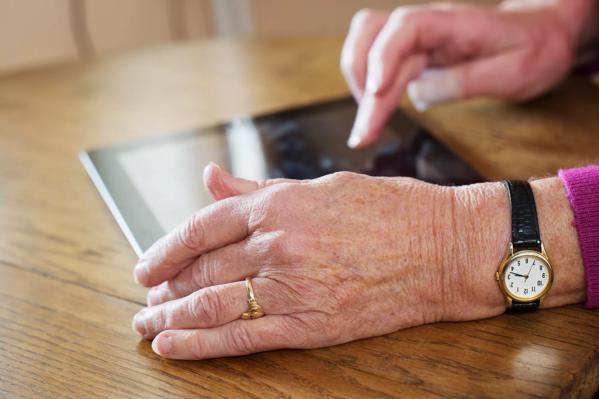 senior woman&#8217;s hands using digital tablet