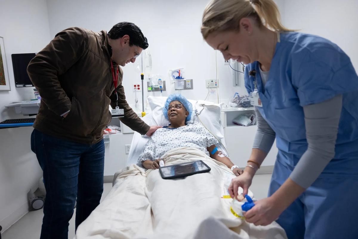 A surgeon talks to a patient in a hospital bed
