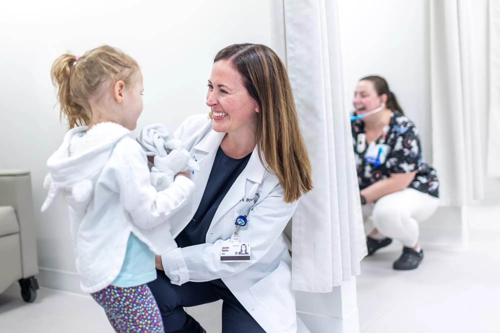 Cleveland Clinic provider smiling and embracing a child.