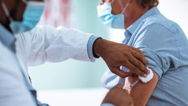 Mature man taking a vaccine from his doctor