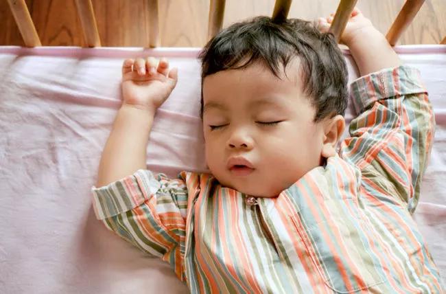 A baby sleeping in a crib.