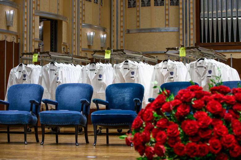 White coats on stage at ceremony.