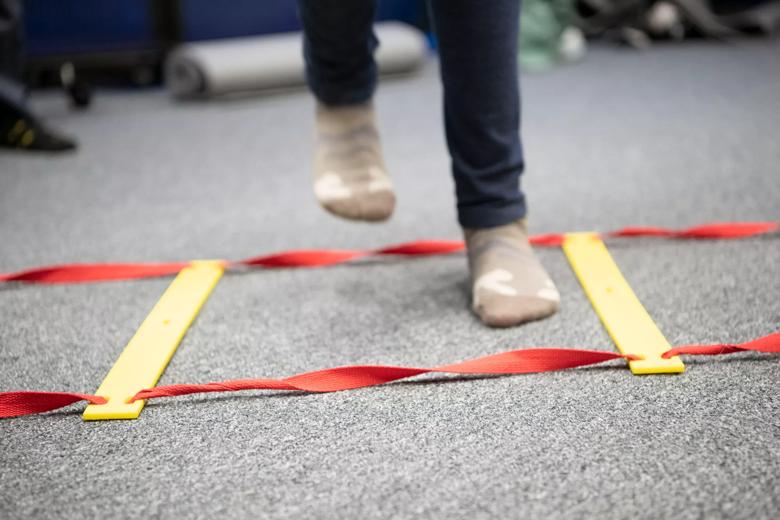 Feet in socks stepping into a square on the floor