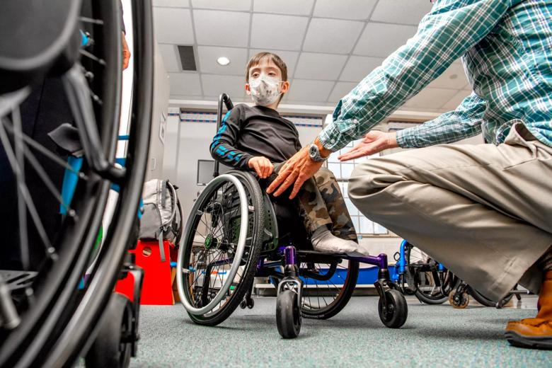 A child sits in a wheelchair