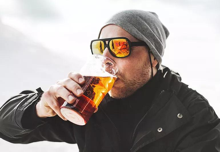 Man having a beer outside during winter