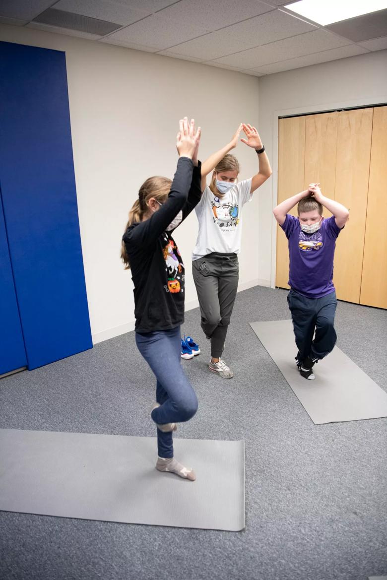 Three people standing on one foot in a yoga position