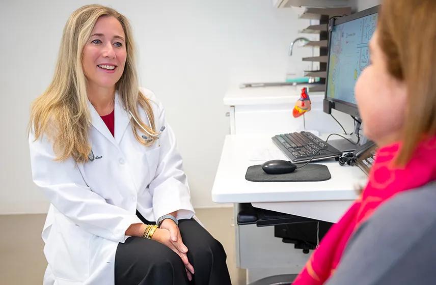 Cardiologist talking with a patient in an exam room.