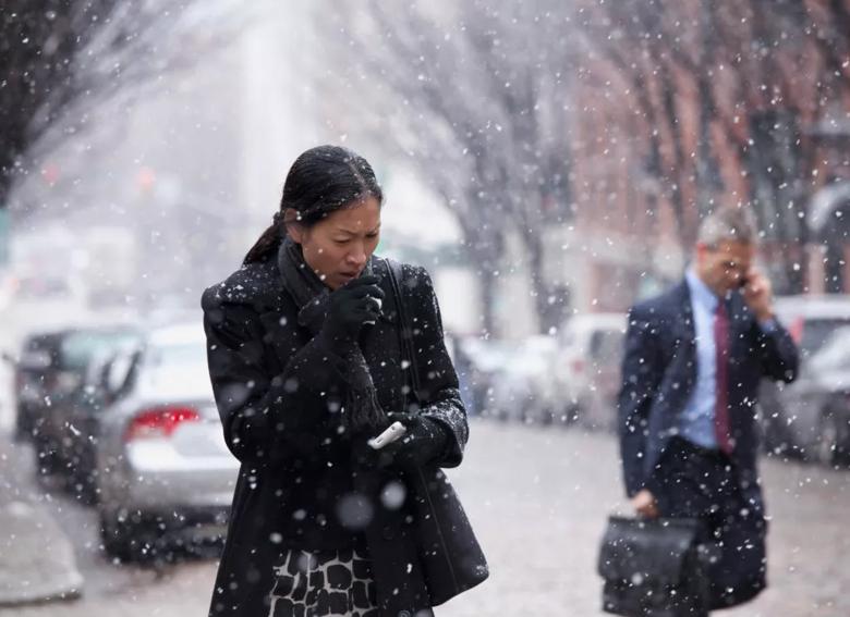 A woman coughing in the snowy weather.