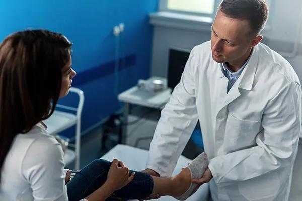 caregiver examining foot for orthotics.