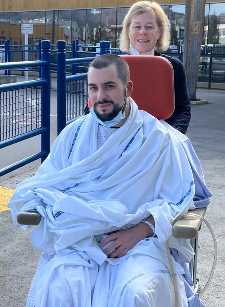 photo of a young man being pushed in a wheelchair