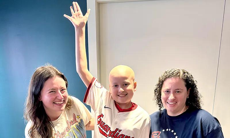 boy lifting his right arm between two young women