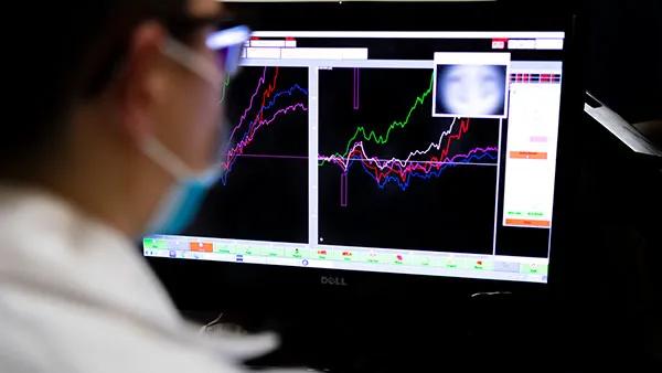 A doctor looking at graphs on a computer