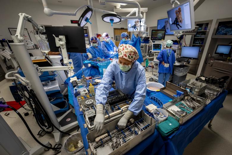 Surgical tech preparing instruments in an operating room