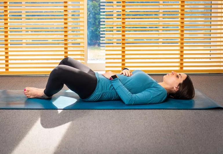 person on yoga mat in reclined cobbler's pose