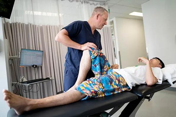 Chiropractor treats young patient on an examination table.