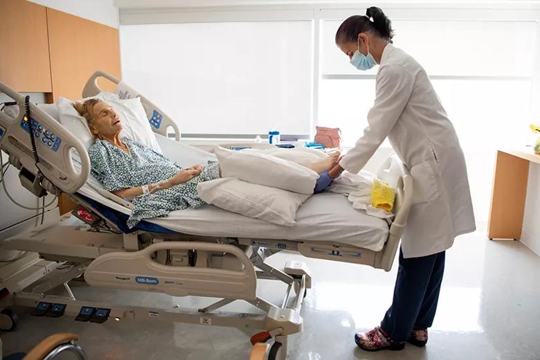 Holistic nurse performing reiki on patient